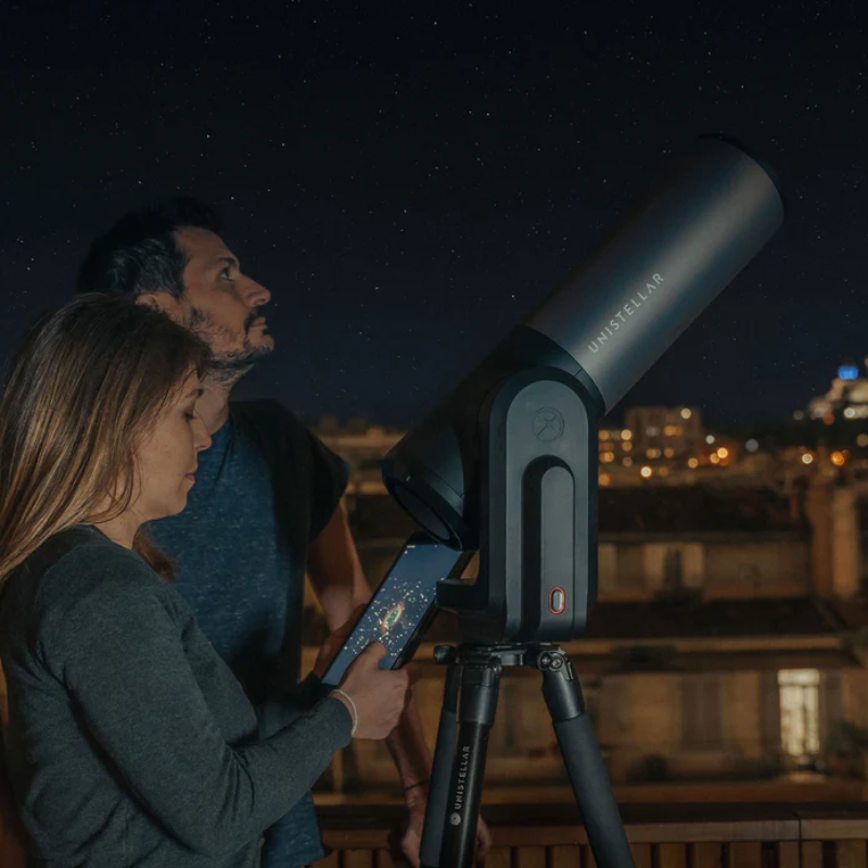 A man and woman using Unistellar eQuinox 2 - Smart Telescope.