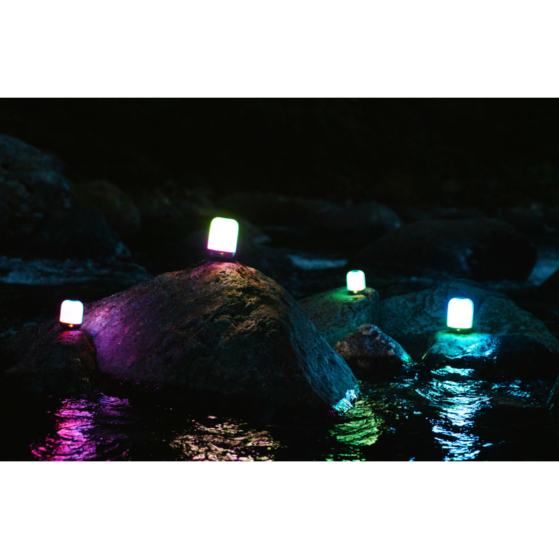 Multiple Alpenglow 250 Lanterns on top of river rocks. 