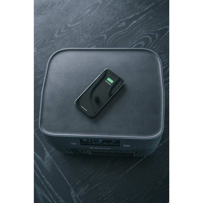 A phone being wirelessly charged on top of BaseCharge 1500.