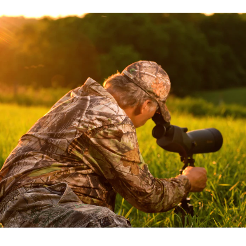 A man slightly facing backward and to the right using the Alpen Shasta Ridge 20-60x80 Waterproof Spotting Scope.
