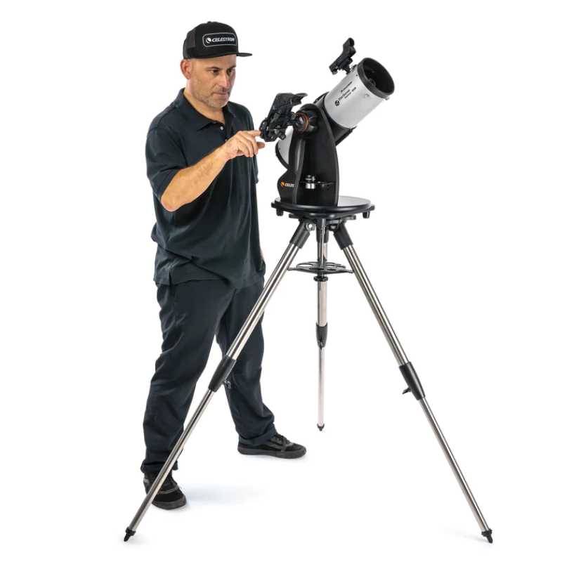 Man standing up using the Starsense Explorer 114mm Smartphone App-Enabled Tabletop Dobsonian Telescope.