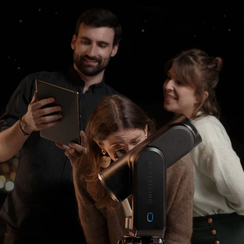 Image of three people using the Unistellar ODYSSEY PRO Smart Telescope.