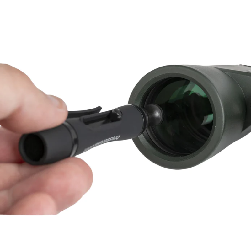 Alpen cleaning pen being used on a binocular lens.